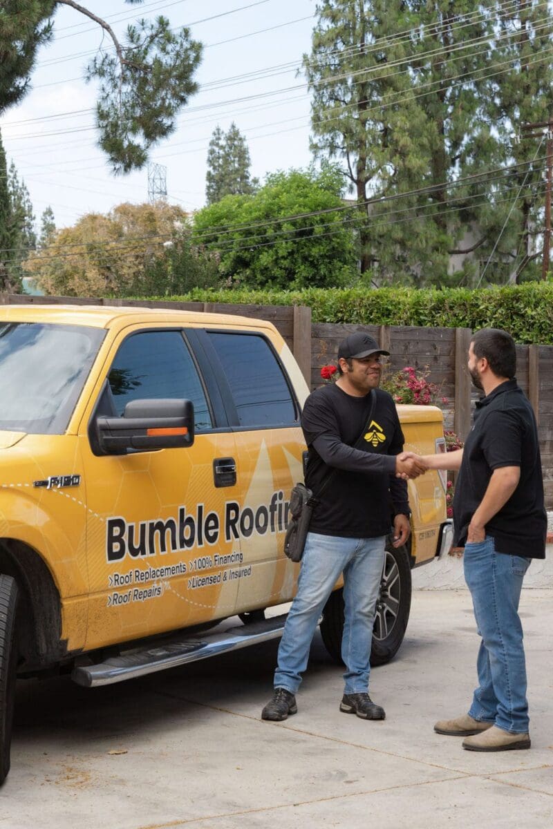 Contractor and home owner shaking hands in driveway