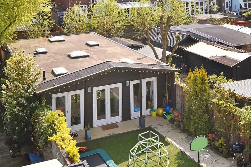 Flat roof on a backyard residential building with multiple skylights.