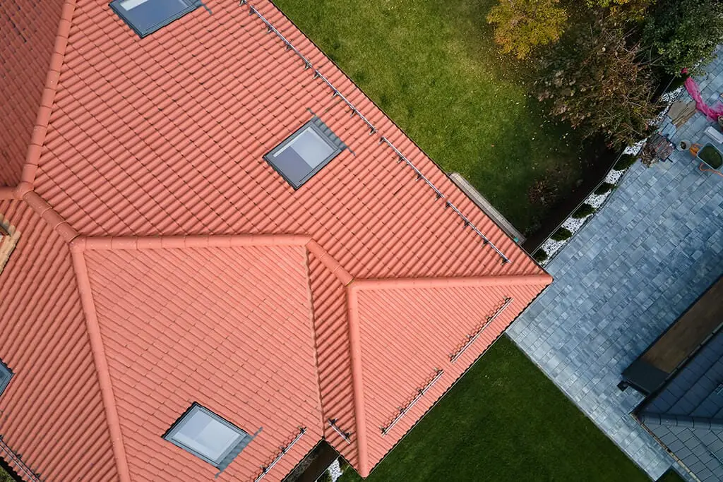 Aerial view of a red tile roof with multiple skylights and snow guards.