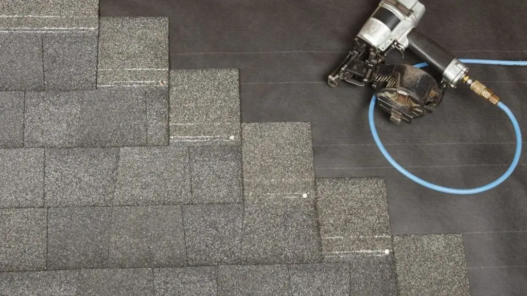 A new roof partially installed with nail gun in frame.