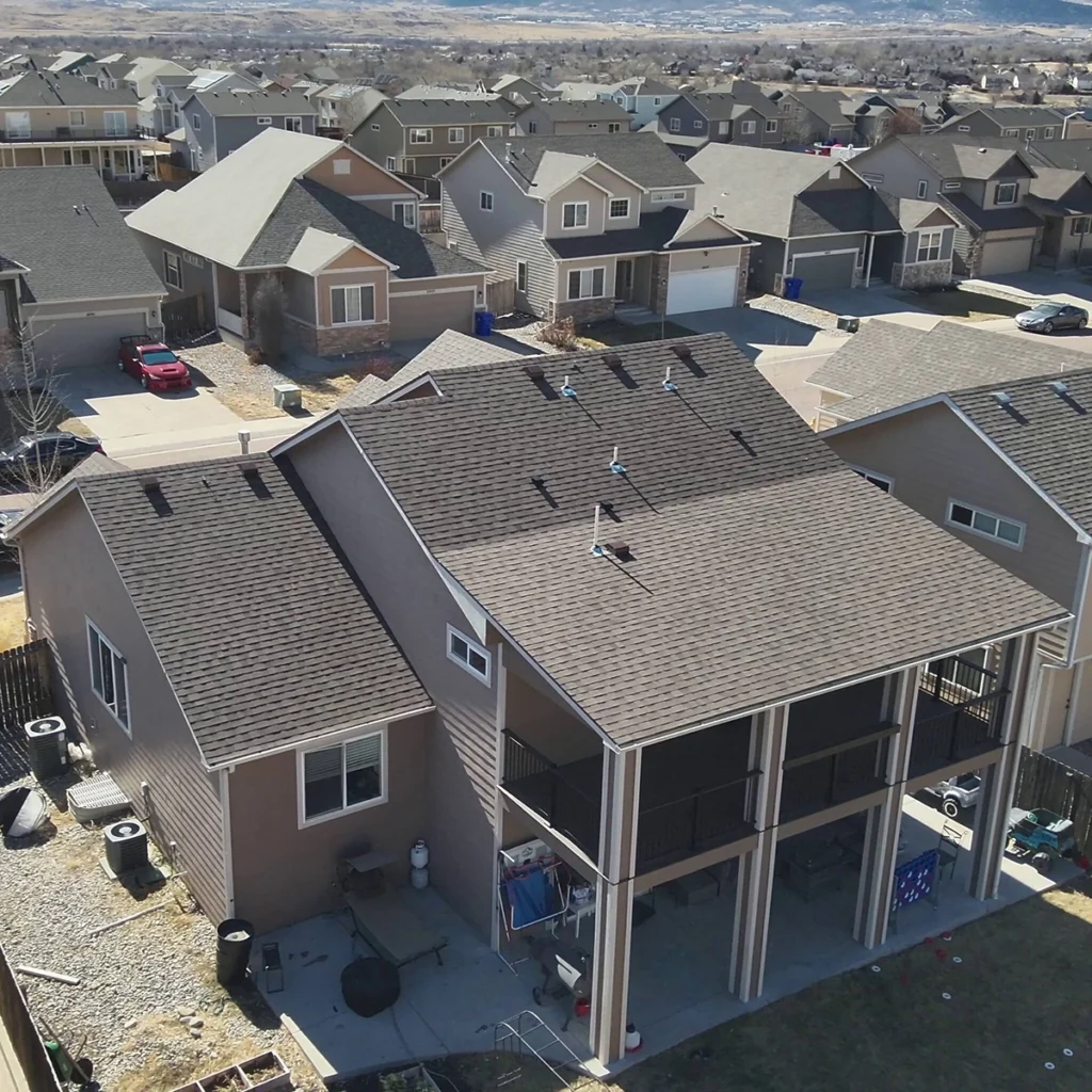 Aerial view of a residential asphalt shingle roof with surrounding homes