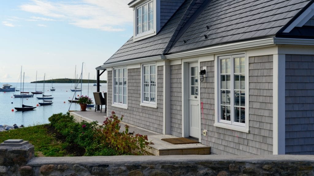 Cottage with a cedar shake roof near a port.