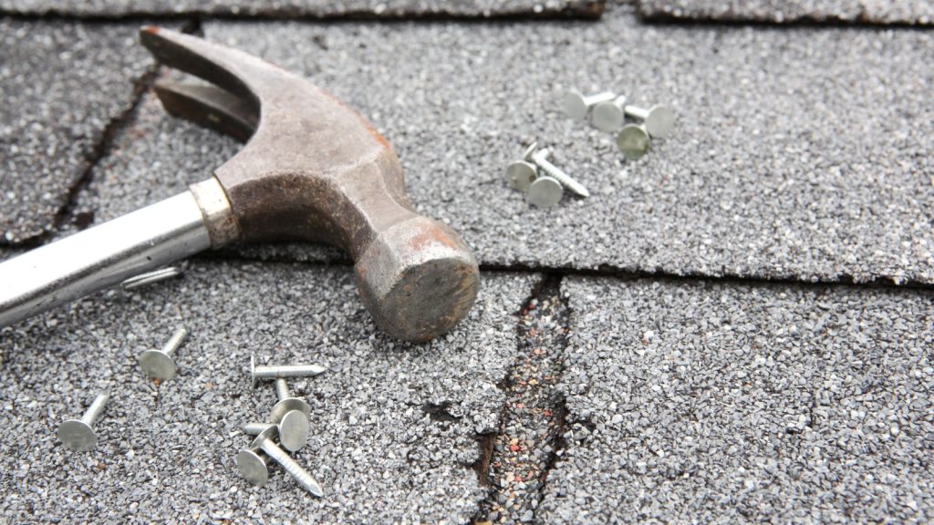 A hammer and nails being used for DIY roof repair. Forsyth County, GA.