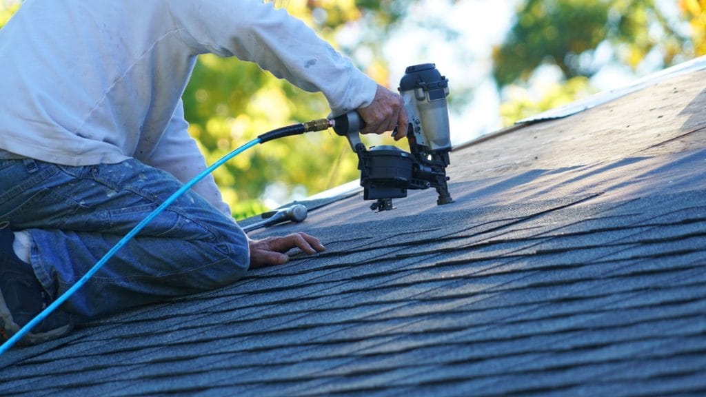 Bumble Roofing using a nail gun to replace shingles on a home in North Atlanta, GA.