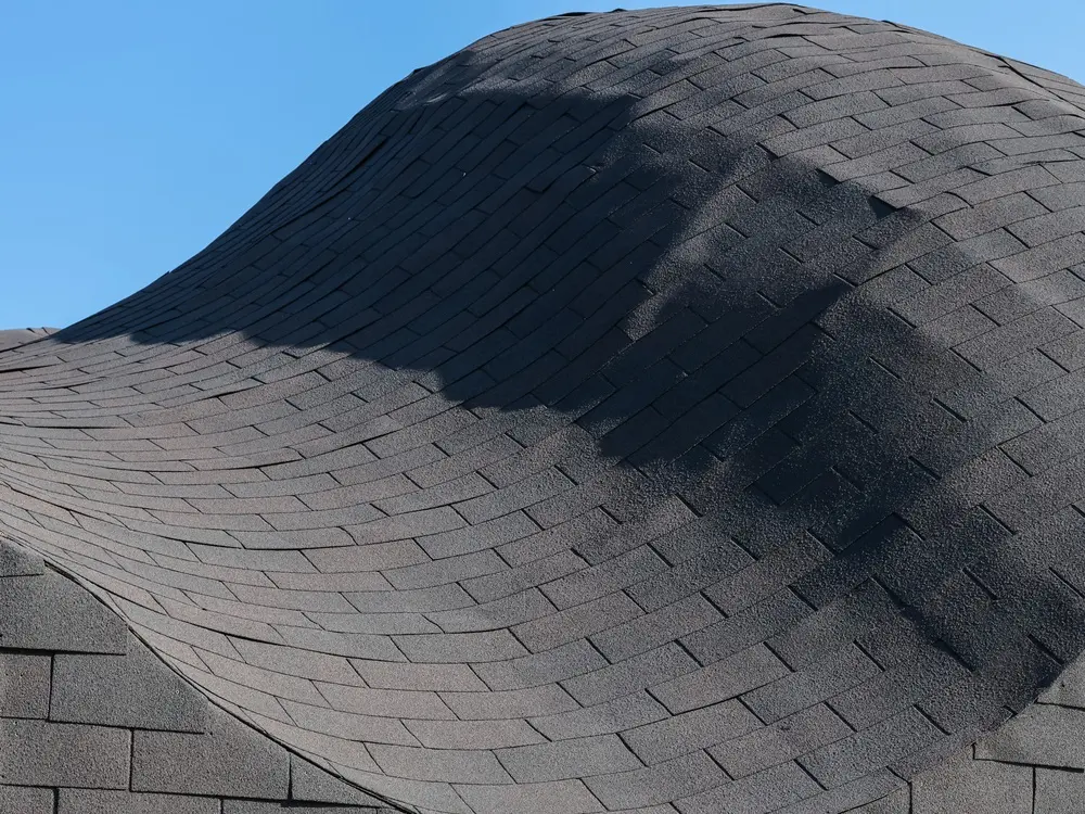 Asphalt roof sagging heavily after severe rainstorm in Richmond, VA.